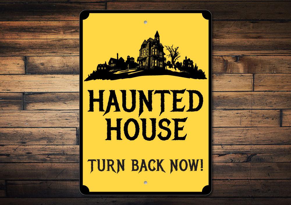 A spooky Haunted House Sign made of durable aluminum, featuring eerie graphics perfect for Halloween decorations.
