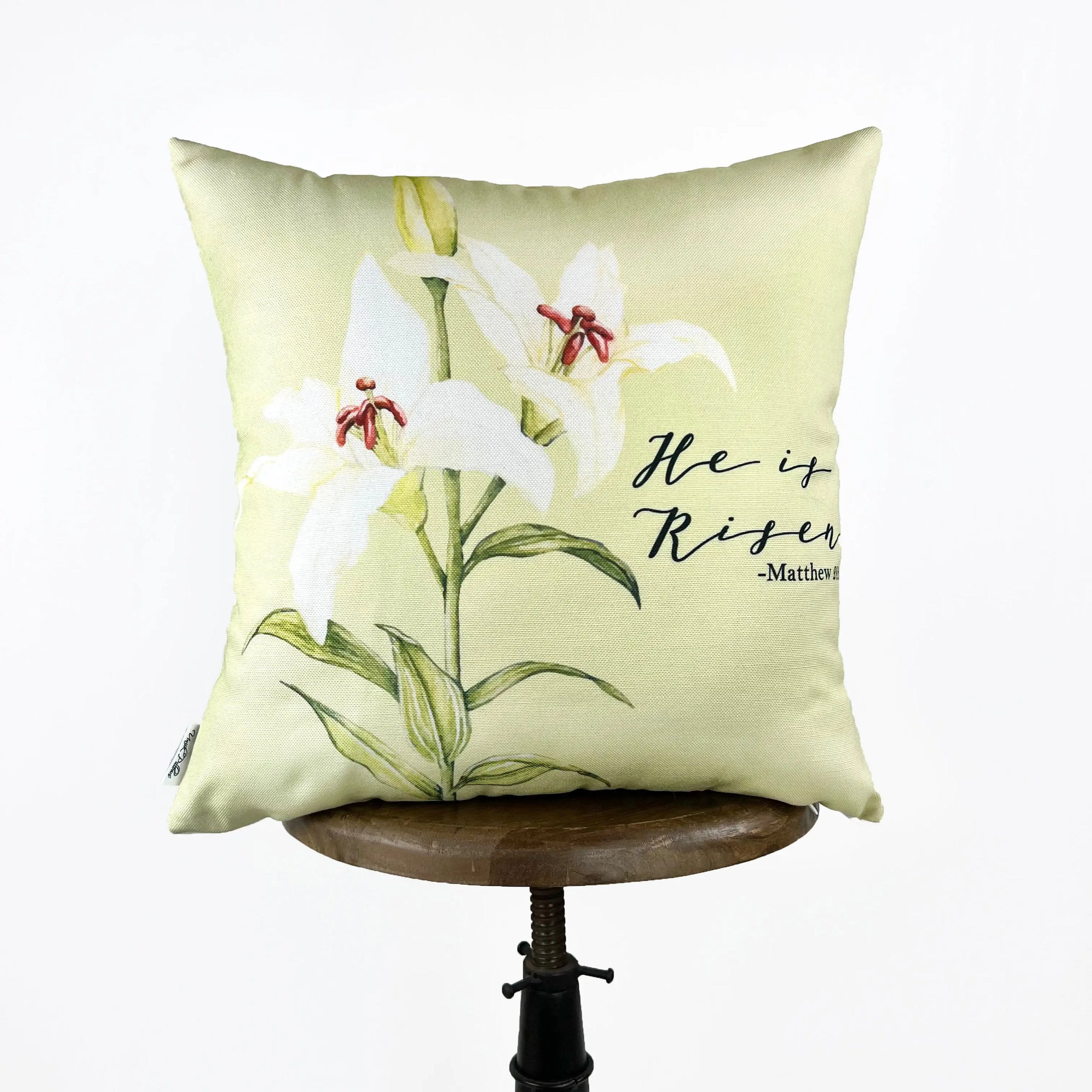 He Is Risen accent pillow with white background and colorful Spring design, perfect for Easter decor.