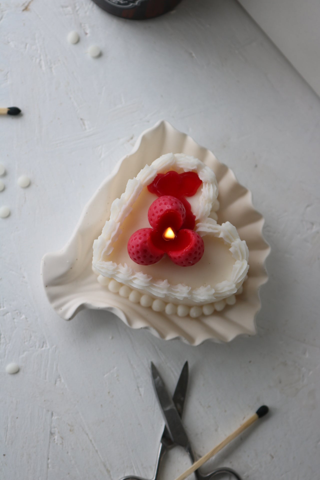 A beautifully crafted heart-shaped cake candle topped with raspberry, made from a soy wax blend, perfect for home decor.