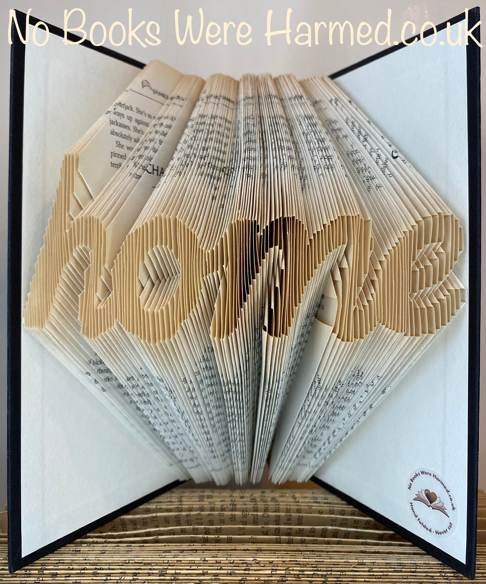 Handcrafted 'home' cursive art made from vintage book pages, showcasing unique folds and colors.