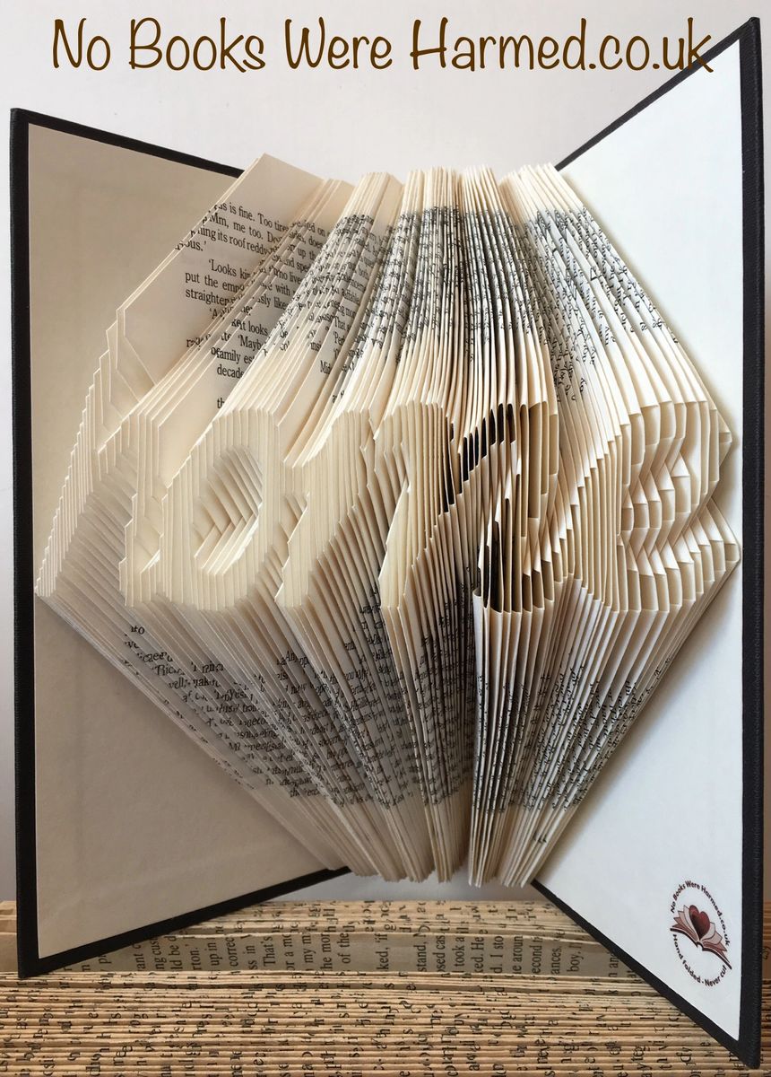 Handcrafted 'home' cursive art made from vintage book pages, showcasing unique folds and colors.