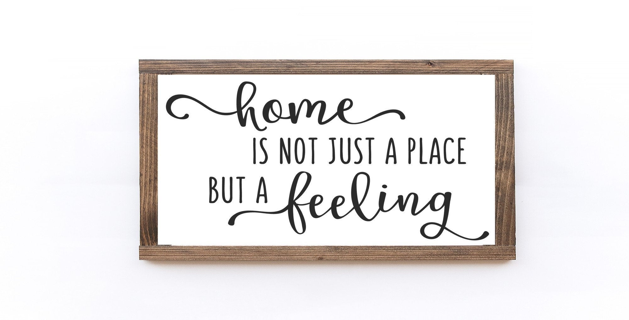 Handcrafted wood sign reading 'Home Is Not Just A Place But A Feeling', featuring a matte white background and unique wood grain.