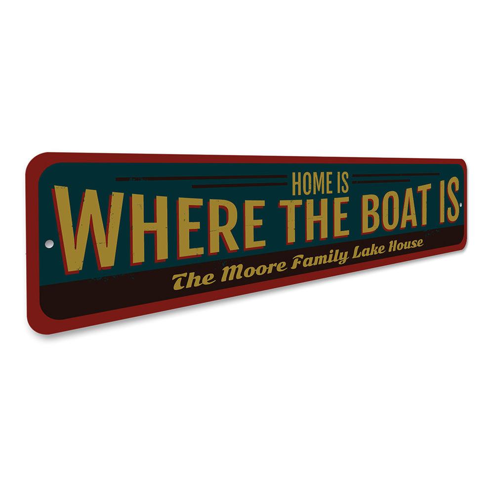 A decorative metal sign reading 'Home is Where the Boat is', showcasing a lakeside theme, perfect for cabin decor.
