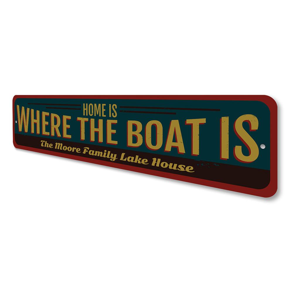 A decorative metal sign reading 'Home is Where the Boat is', showcasing a lakeside theme, perfect for cabin decor.