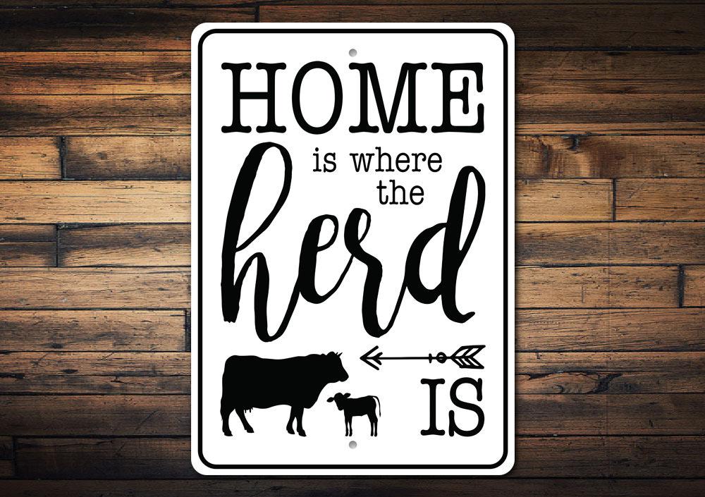 A decorative metal sign reading 'Home is Where the Herd is', showcasing quality aluminum craftsmanship with a rustic design.