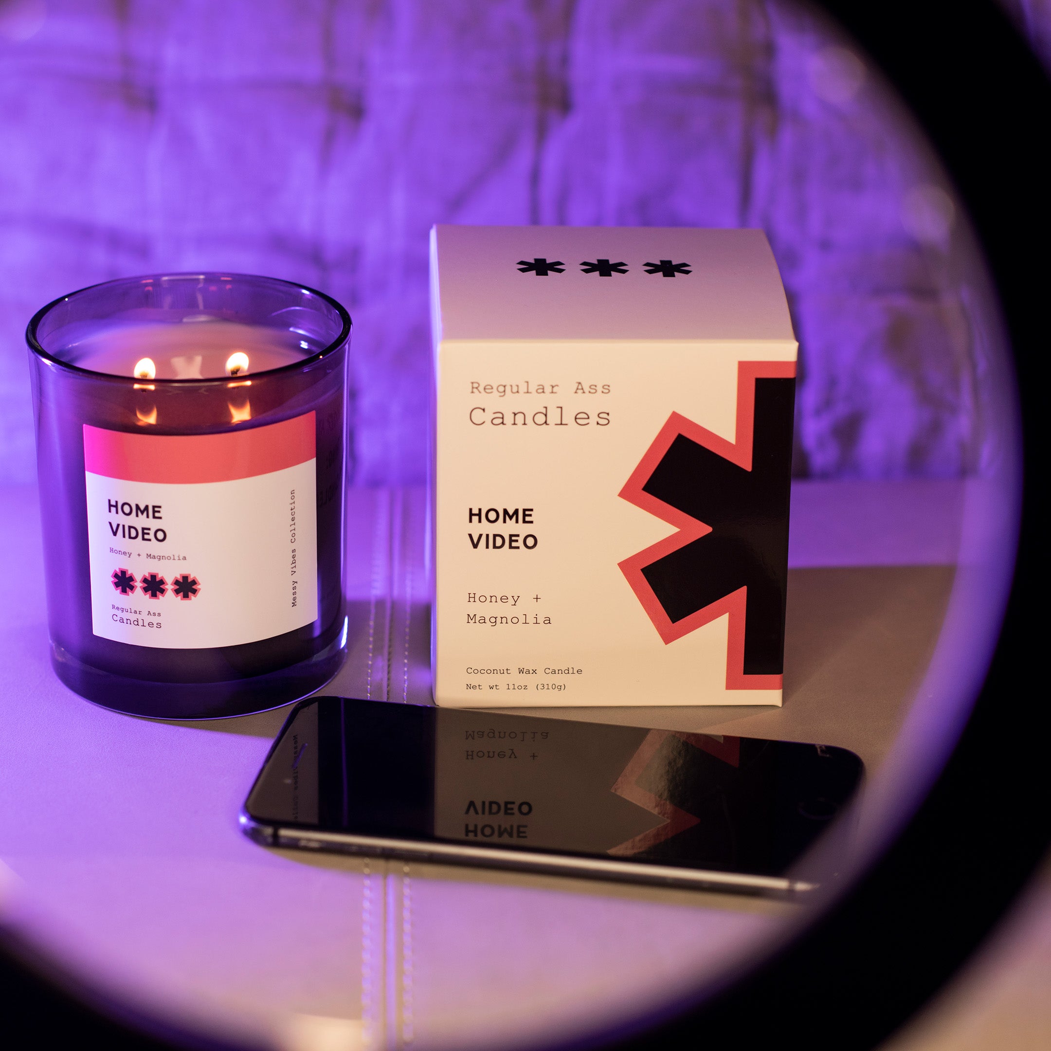 Home Video Honey + Toffee 11oz Candle in a stylish jar with a warm glow, showcasing its floral and sweet fragrance.