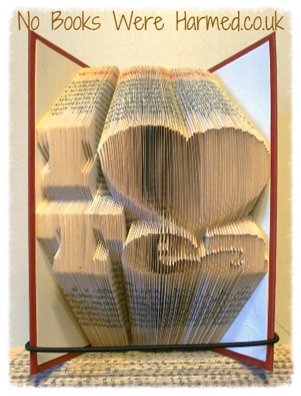 Handcrafted 'I ♥ Tea' book art made from vintage pages, showcasing unique folds and colors.