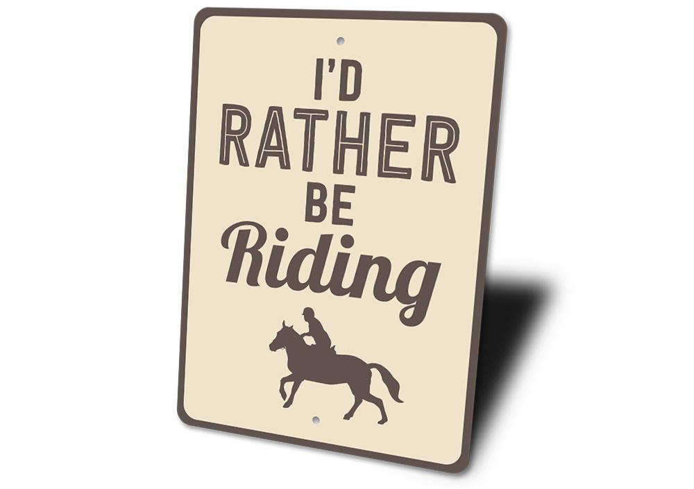 A decorative 'I'd Rather Be Riding' sign made of high-quality aluminum, featuring a rustic design suitable for indoor and outdoor display.