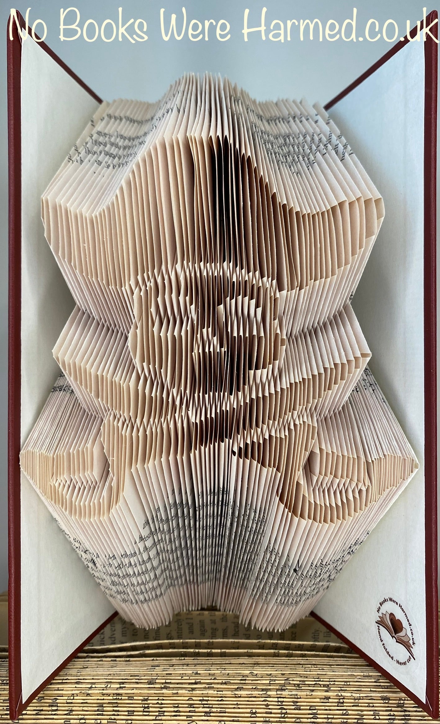 Handcrafted Jolly Roger book art made from vintage books, showcasing intricate page folds and unique design.