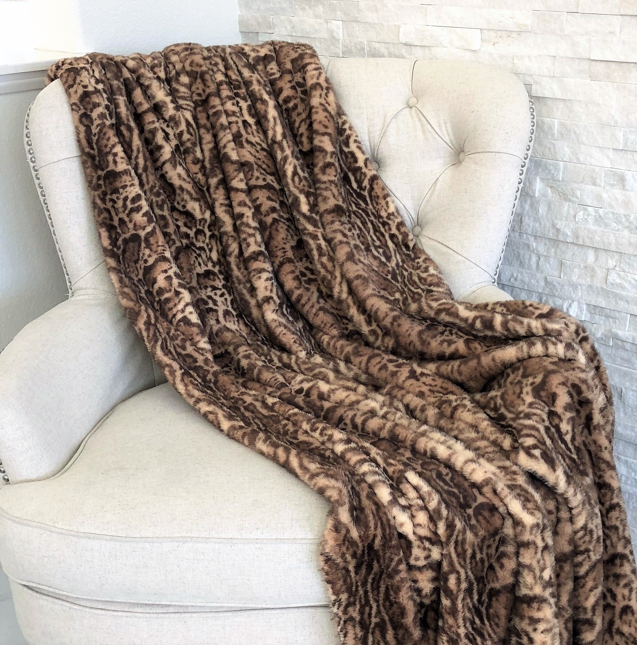 Jungle Cat Faux Fur Luxury Throw in brown and beige, showcasing its plush texture and high/low pile design.