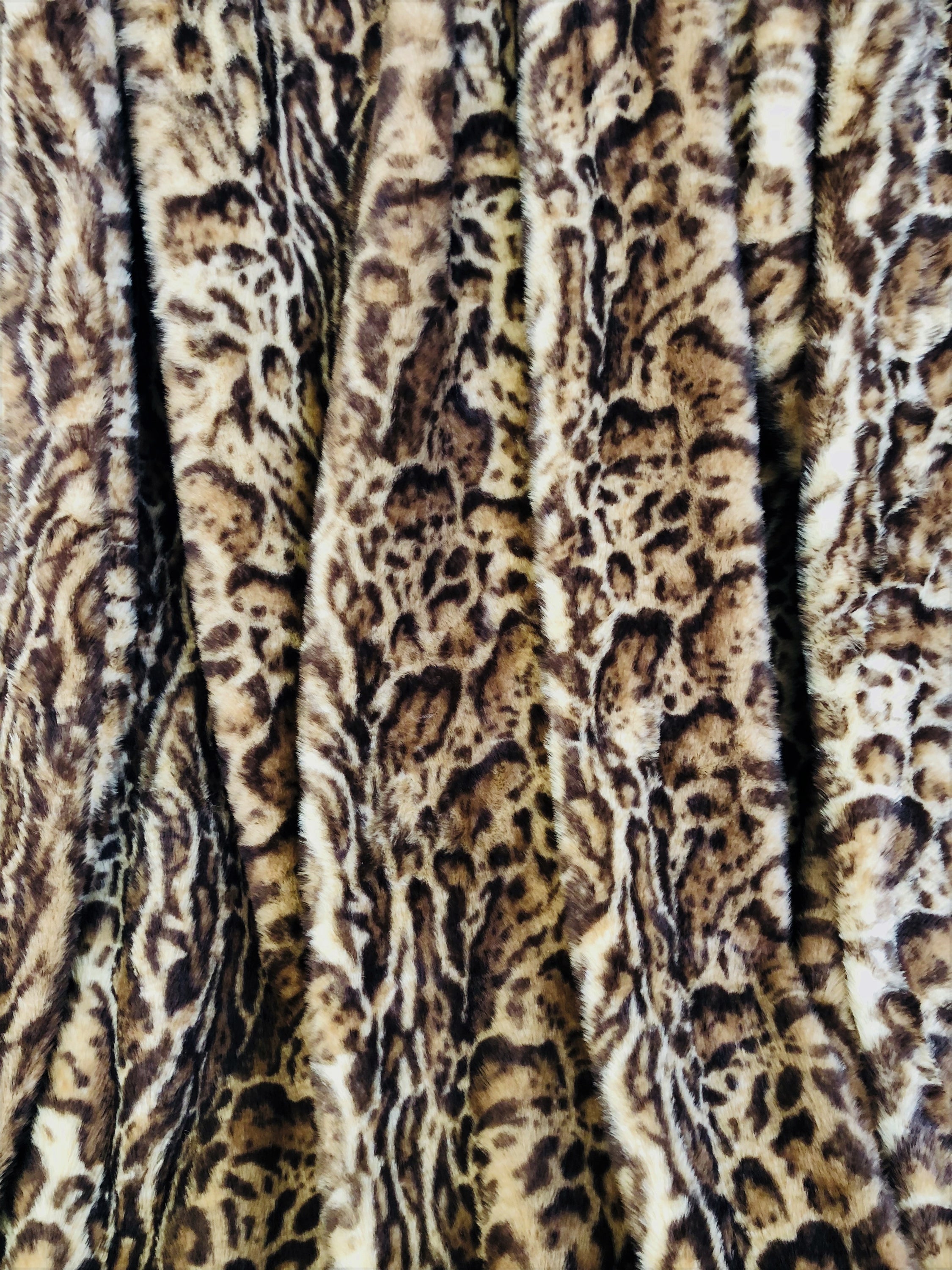 Jungle Cat Faux Fur Luxury Throw in brown and beige, showcasing its plush texture and high/low pile design.