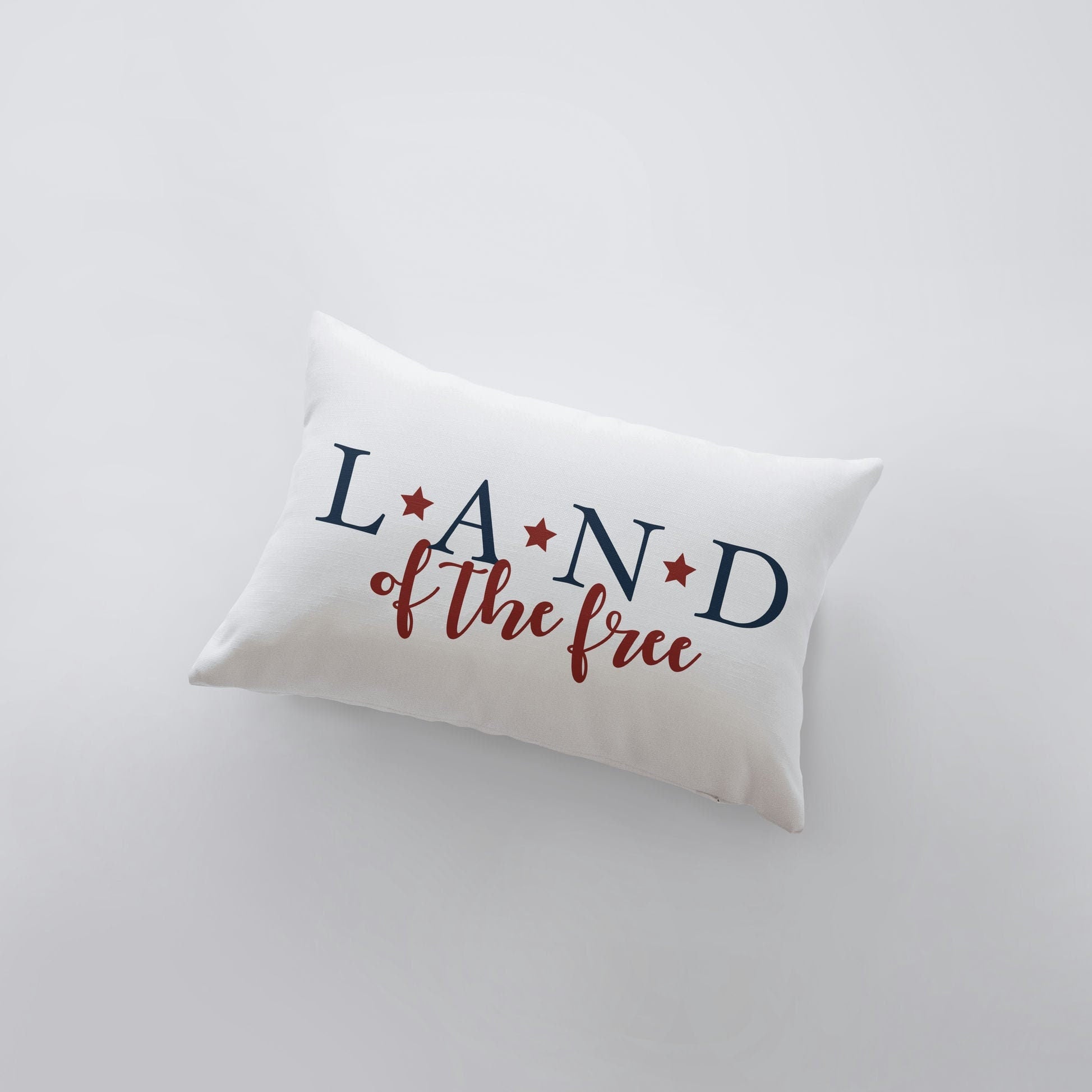 Hand-made 'Land of the Free' pillow cover featuring patriotic lettering on a brown background, perfect for Fourth of July and Memorial Day decor.