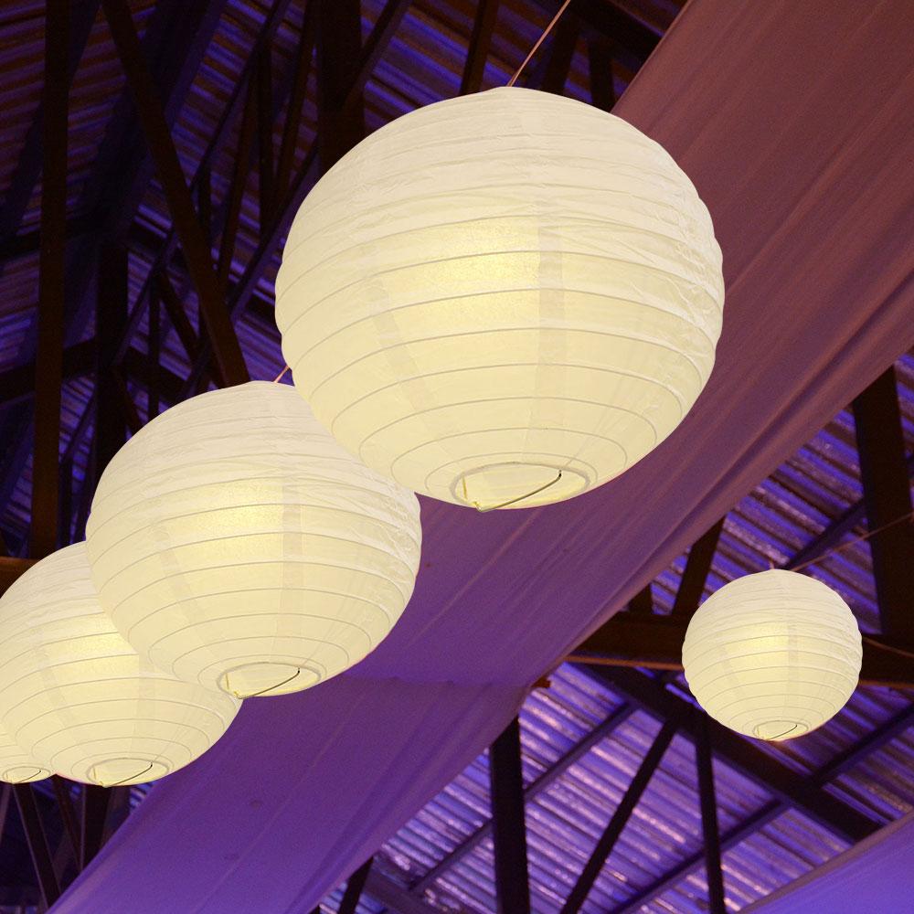 A set of colorful LED paper lantern lights hanging outdoors, illuminating a wedding venue with a warm glow.