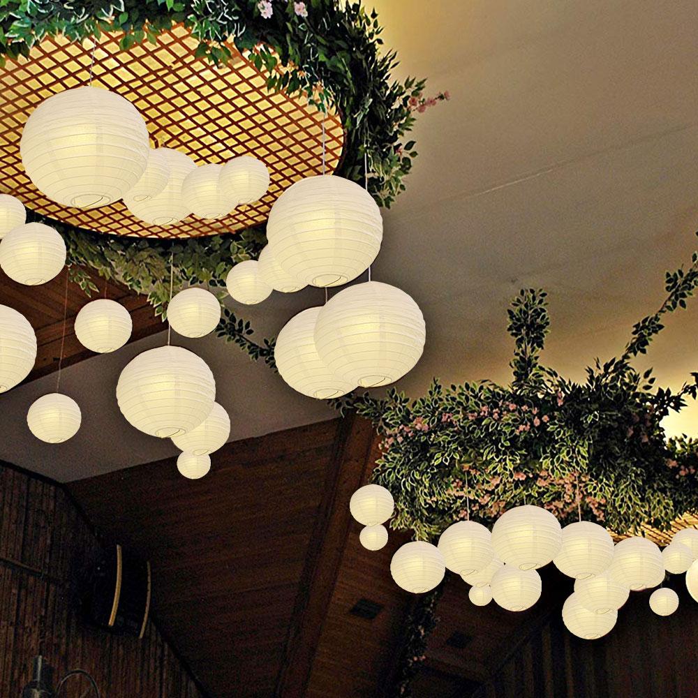 A set of colorful LED paper lantern lights hanging outdoors, illuminating a wedding venue with a warm glow.