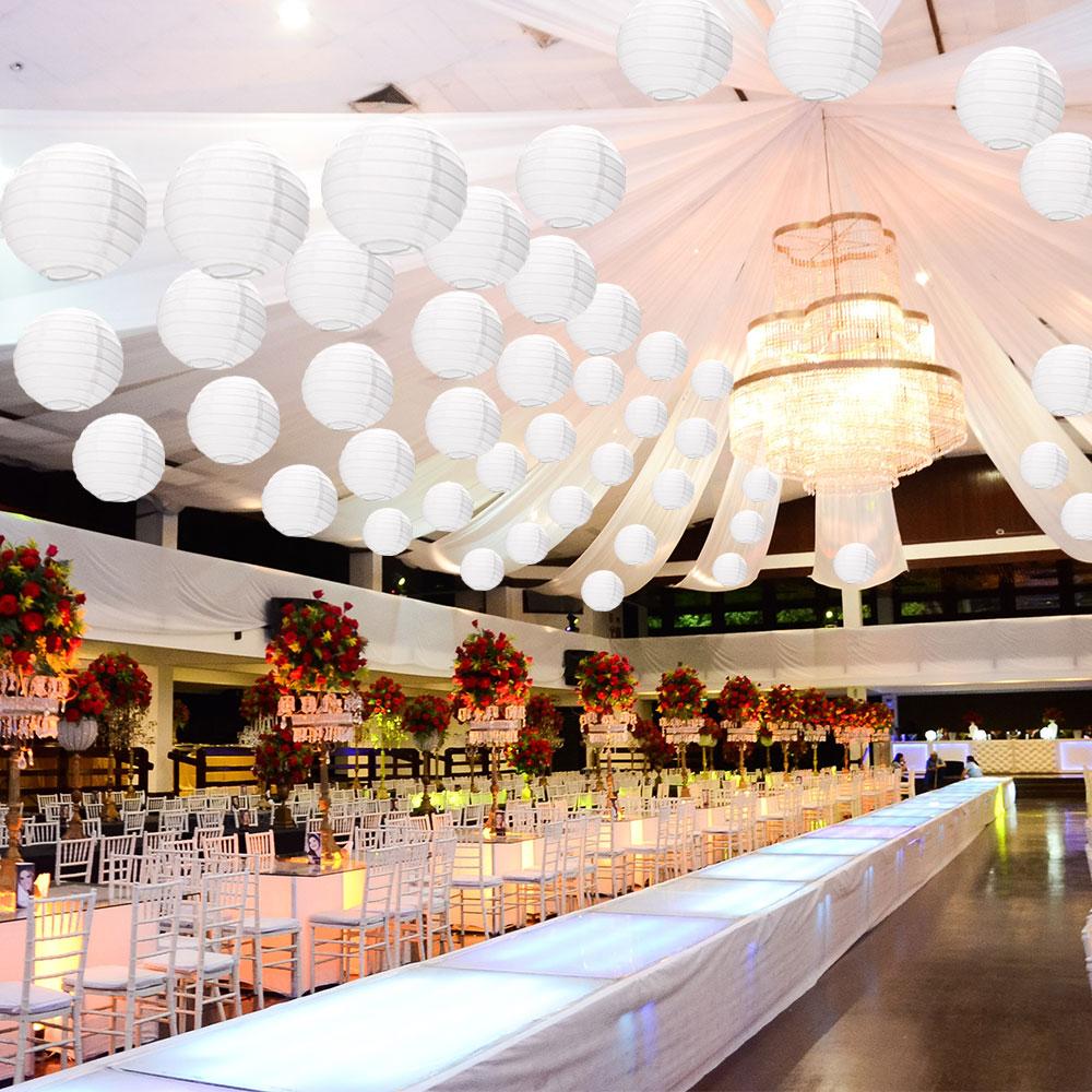 A set of colorful LED paper lantern lights hanging outdoors, illuminating a wedding venue with a warm glow.