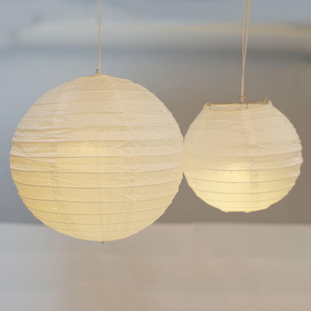 A set of colorful LED paper lantern lights hanging outdoors, illuminating a wedding venue with a warm glow.