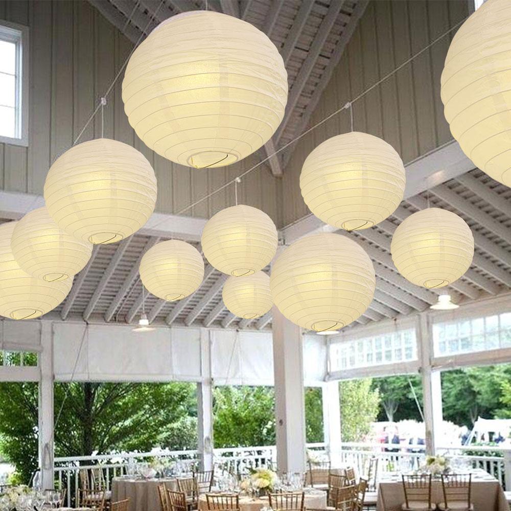 A set of colorful LED paper lantern lights hanging outdoors, illuminating a wedding venue with a warm glow.
