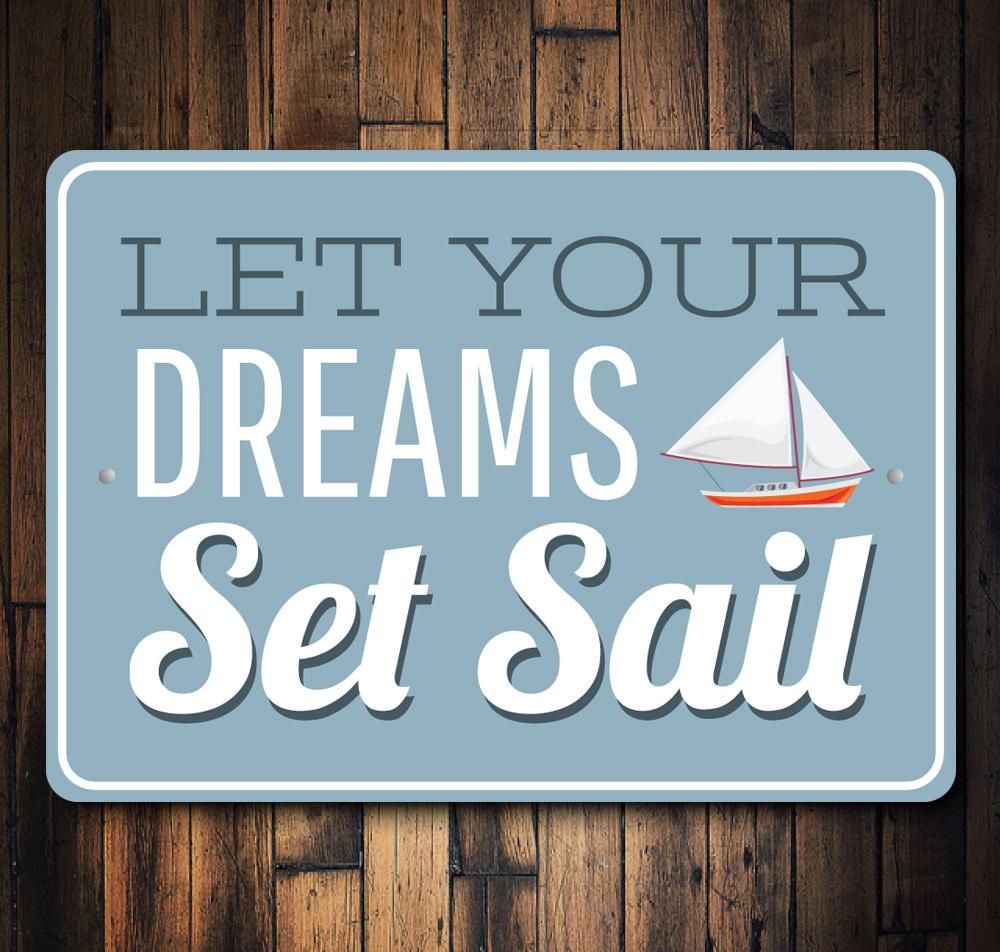 A decorative metal sign reading 'Let Your Dreams Set Sail', showcasing a beautiful lake theme, perfect for lakehouses and outdoor decor.