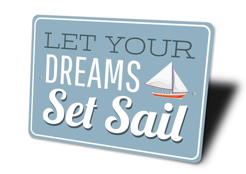 A decorative metal sign reading 'Let Your Dreams Set Sail', showcasing a beautiful lake theme, perfect for lakehouses and outdoor decor.
