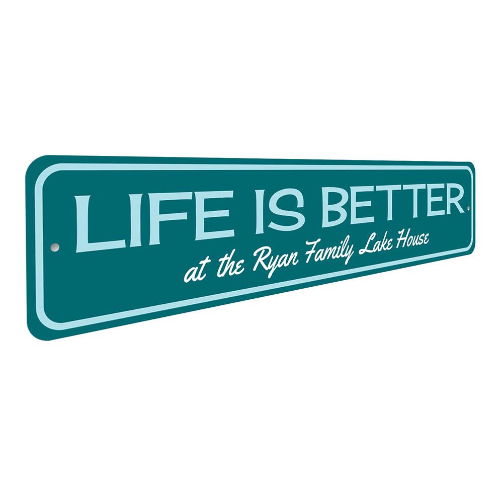 A decorative metal sign reading 'Life Is Better at the Lake', showcasing a beautiful lakeside theme, perfect for lakehouse decor.