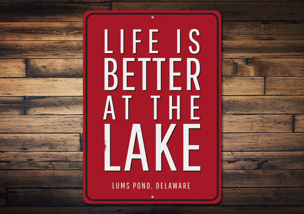 A decorative Life Is Better At The Lake location sign made of high-quality aluminum, showcasing a beautiful lake-themed design.