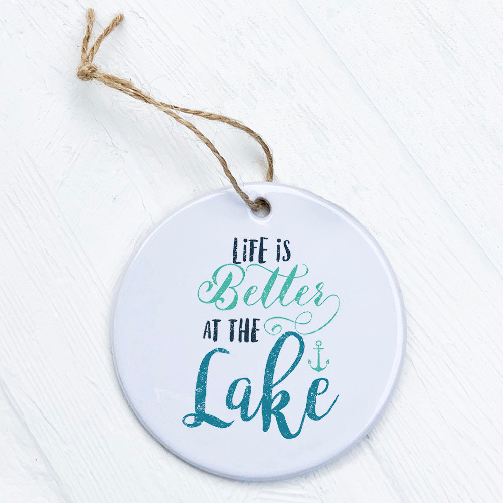 A beautifully crafted porcelain ornament featuring the phrase 'Life is Better at the Lake', showcasing vibrant colors and a smooth finish.