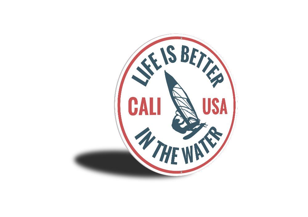 Decorative metal sign reading 'Life is Better in the Water', featuring a beach-themed design, perfect for coastal homes.