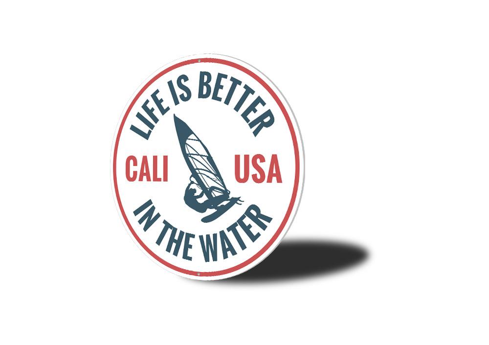 Decorative metal sign reading 'Life is Better in the Water', featuring a beach-themed design, perfect for coastal homes.
