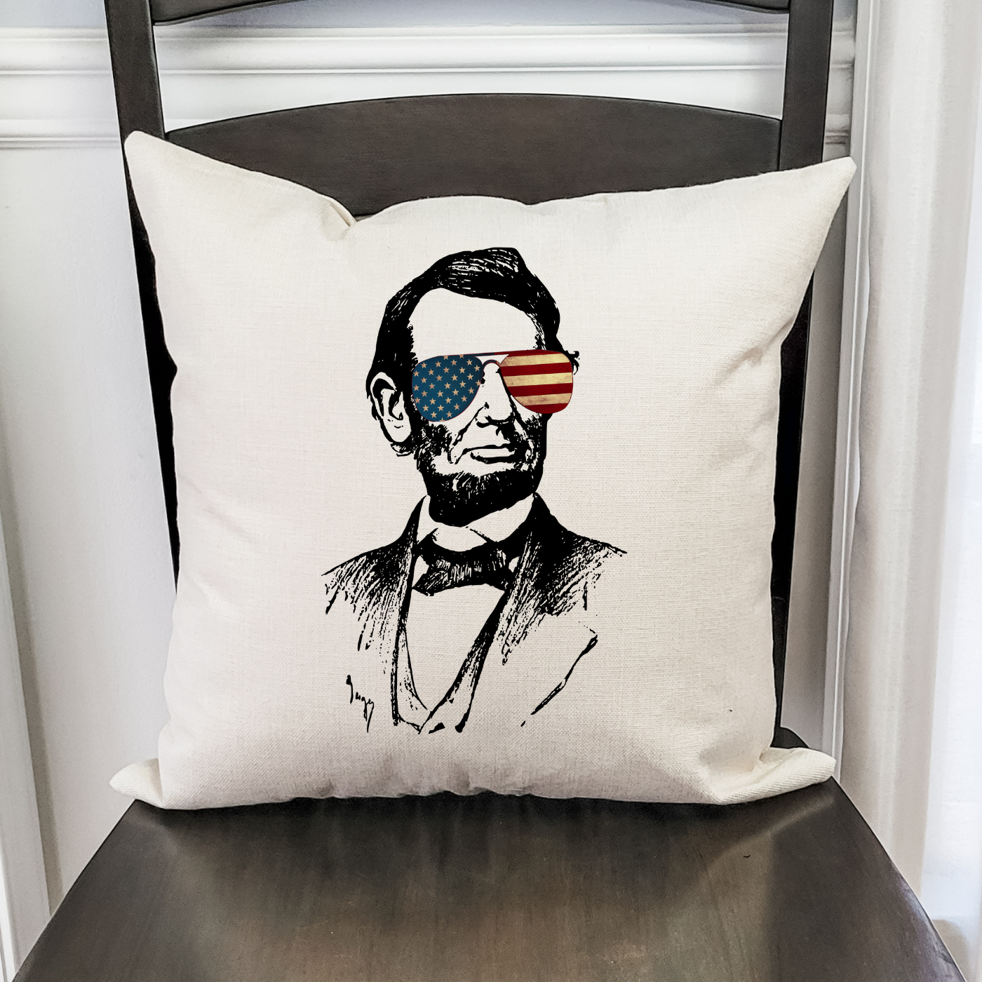 Lincoln Sunglasses Pillow Cover featuring a patriotic design on a light beige background, with a hidden zipper for easy use.