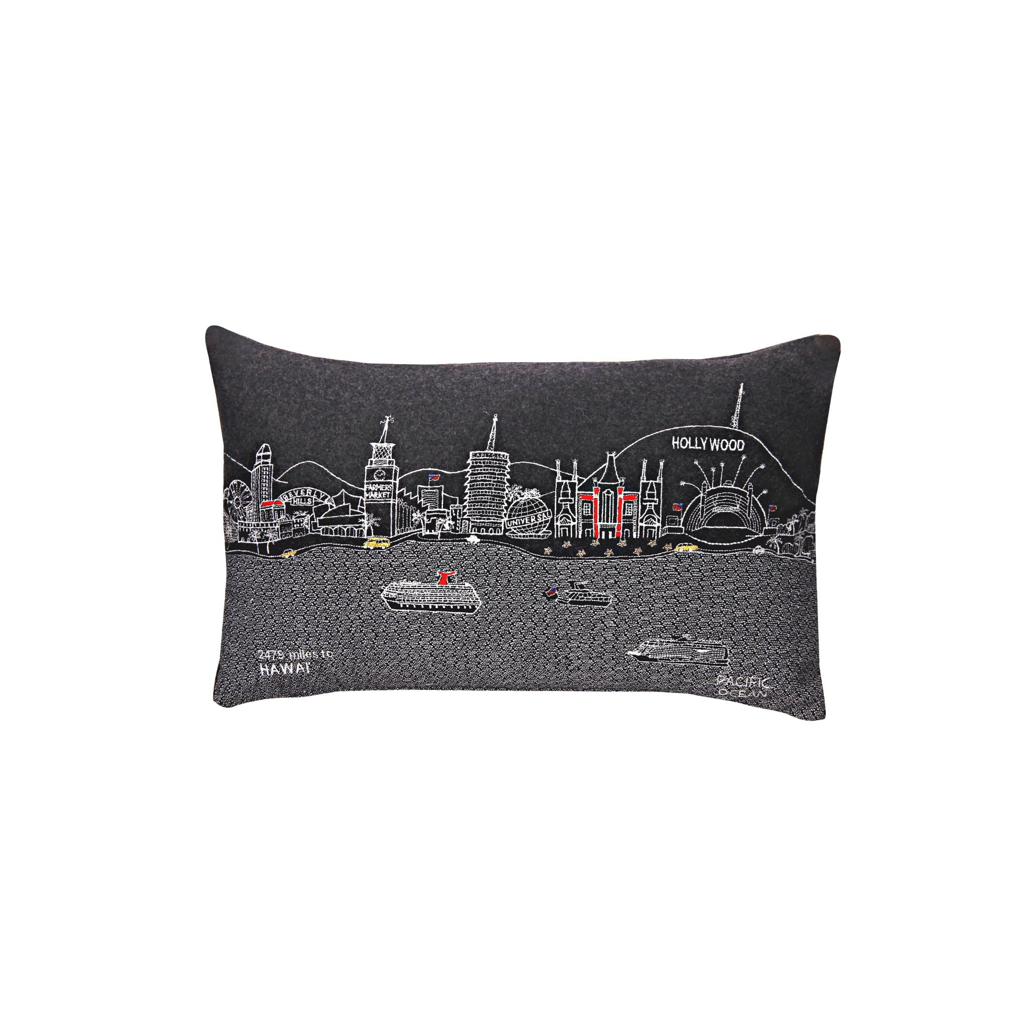 Los Angeles Pillow featuring embroidered landmarks like the Hollywood Sign and Griffith Observatory, with a red zipper at the bottom.