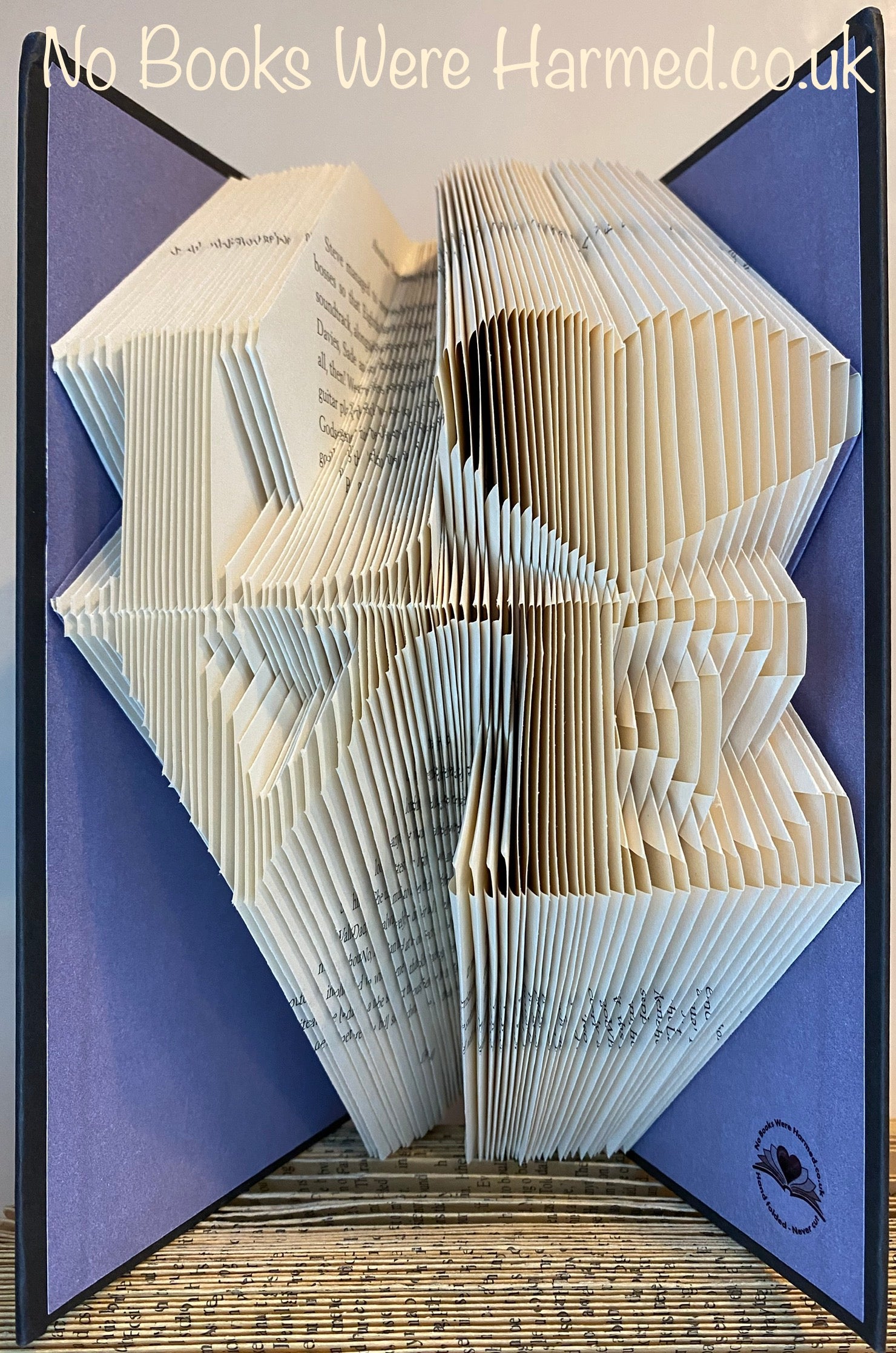 Handcrafted 'Love' square art piece made from vintage book pages, featuring a heart-shaped 'o' design, showcasing unique colors and textures.