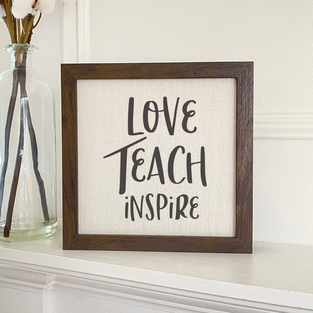 Love Teach Inspire framed sign with a stylish wood frame and linen-look background, perfect for home decor.