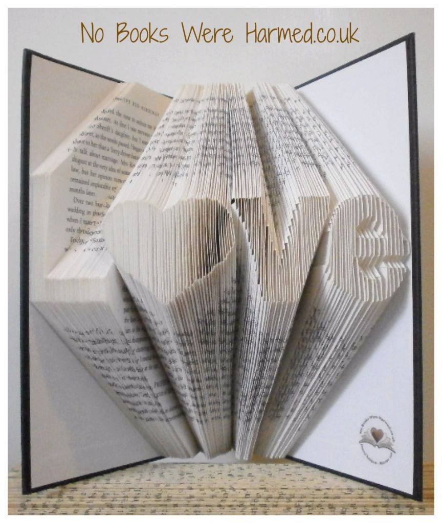 Hand-folded book art piece shaped as 'L♥ve' with a heart for 'o', crafted from vintage books.