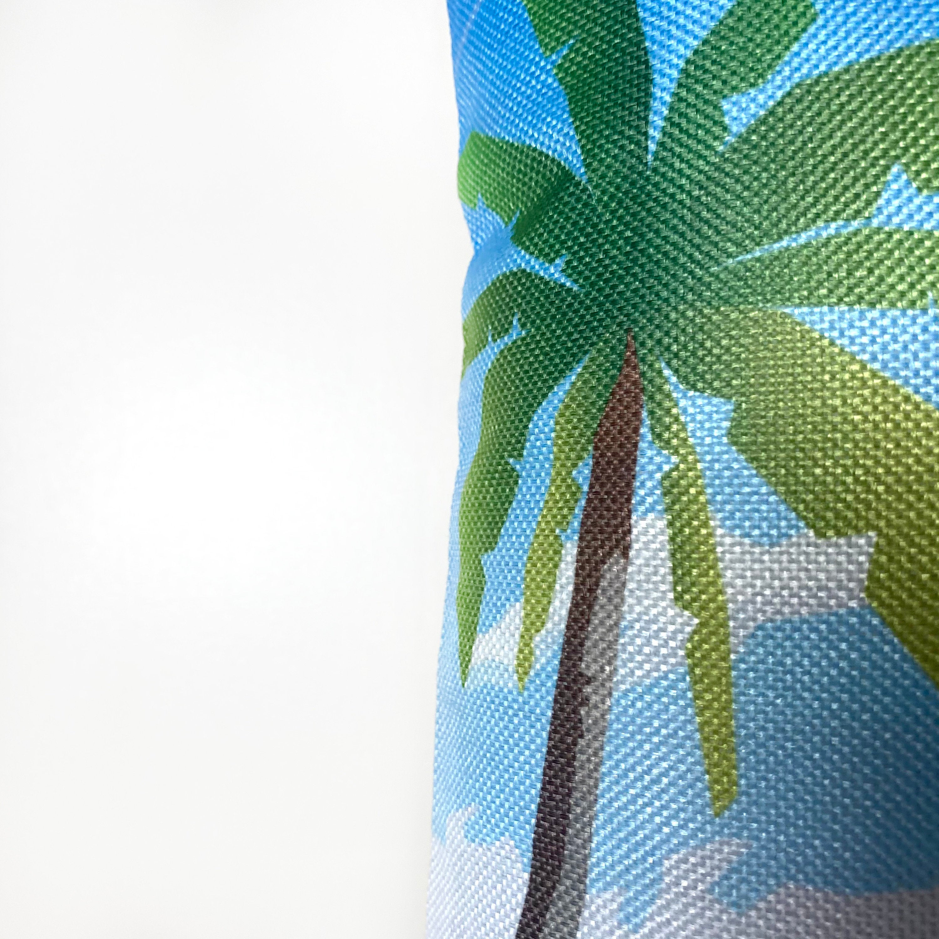A vibrant 12x18 pillow cover featuring a travel poster of a beach in the Maldives, showcasing tropical colors and a concealed zipper.