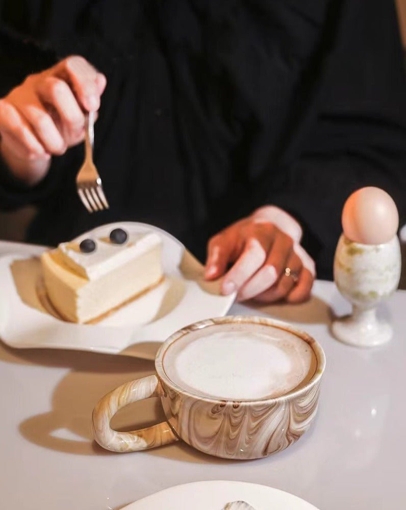 Stylish marbleized ceramic mug with elegant design, perfect for coffee or tea.