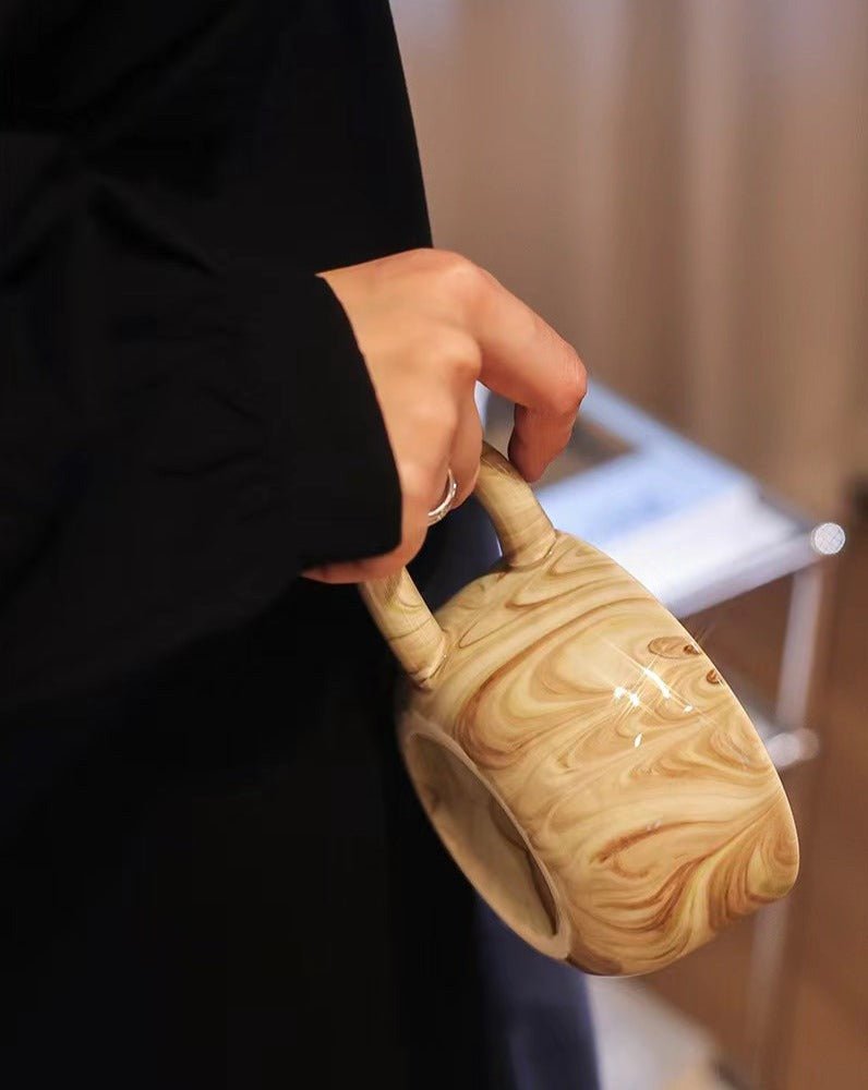 Stylish marbleized ceramic mug with elegant design, perfect for coffee or tea.