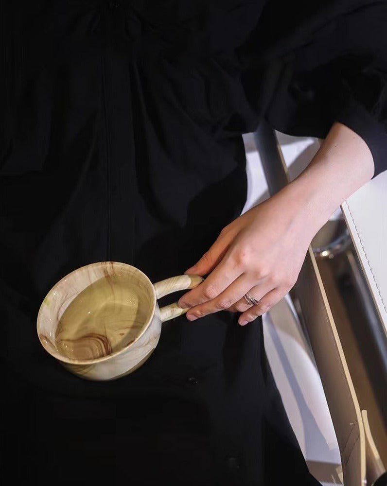 Stylish marbleized ceramic mug with elegant design, perfect for coffee or tea.