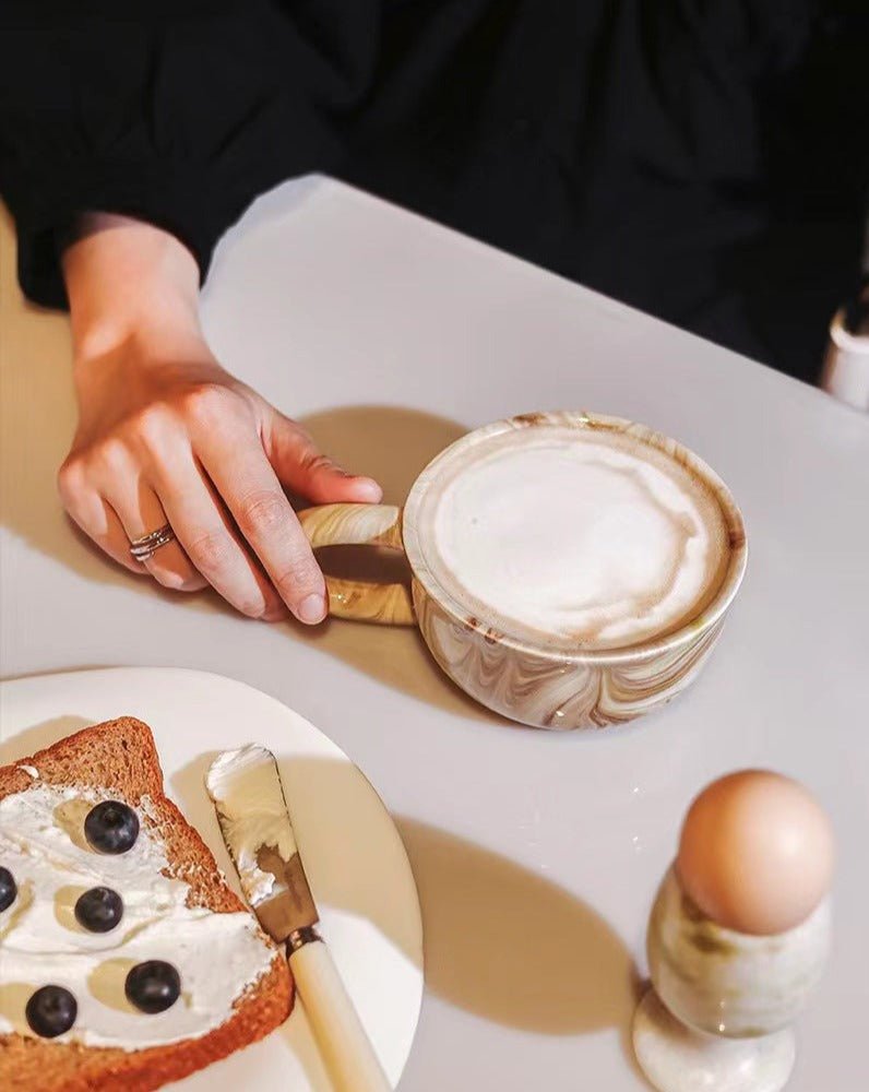 Stylish marbleized ceramic mug with elegant design, perfect for coffee or tea.