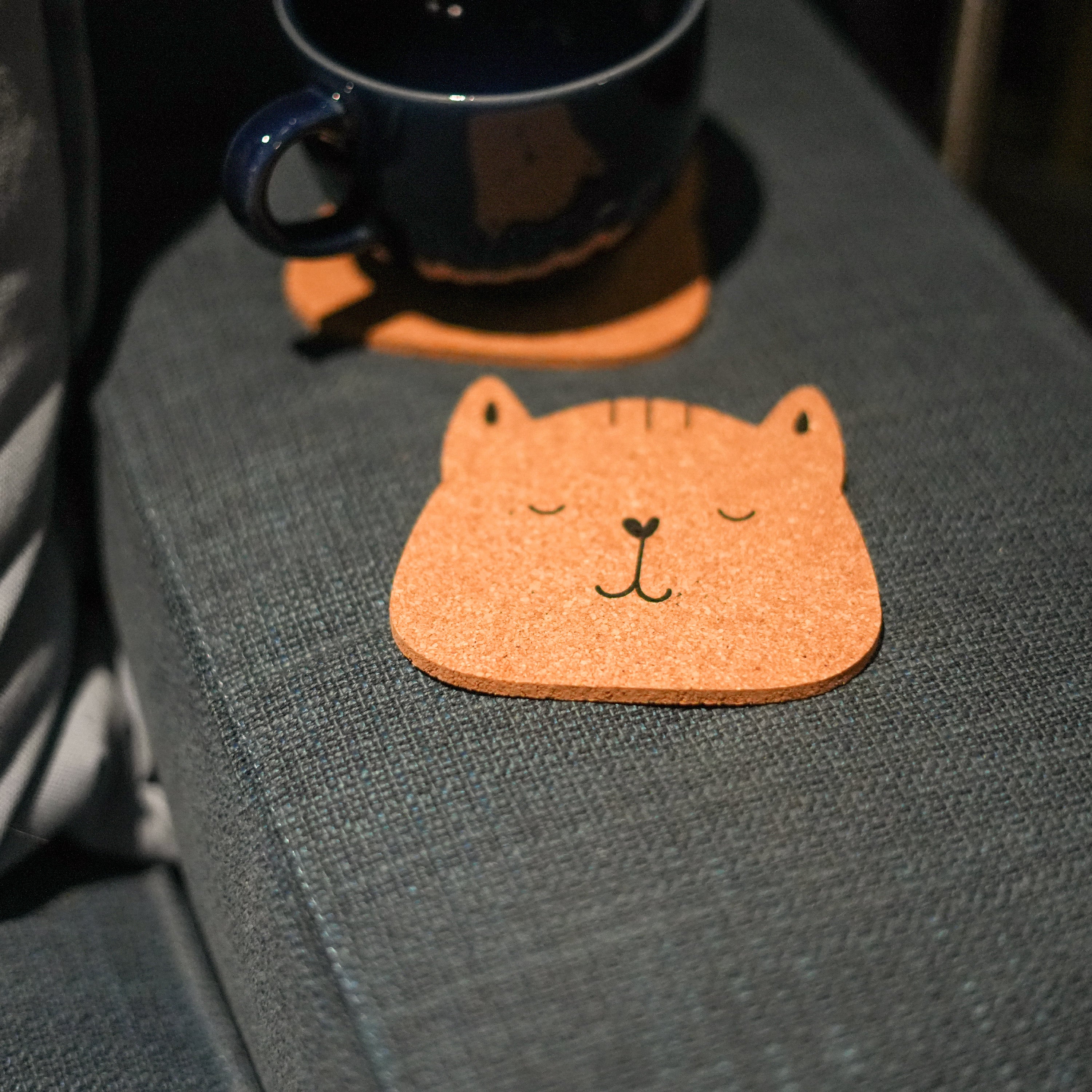 Set of 6 round cork coasters featuring different cute cat faces, perfect for protecting furniture and showcasing love for cats.