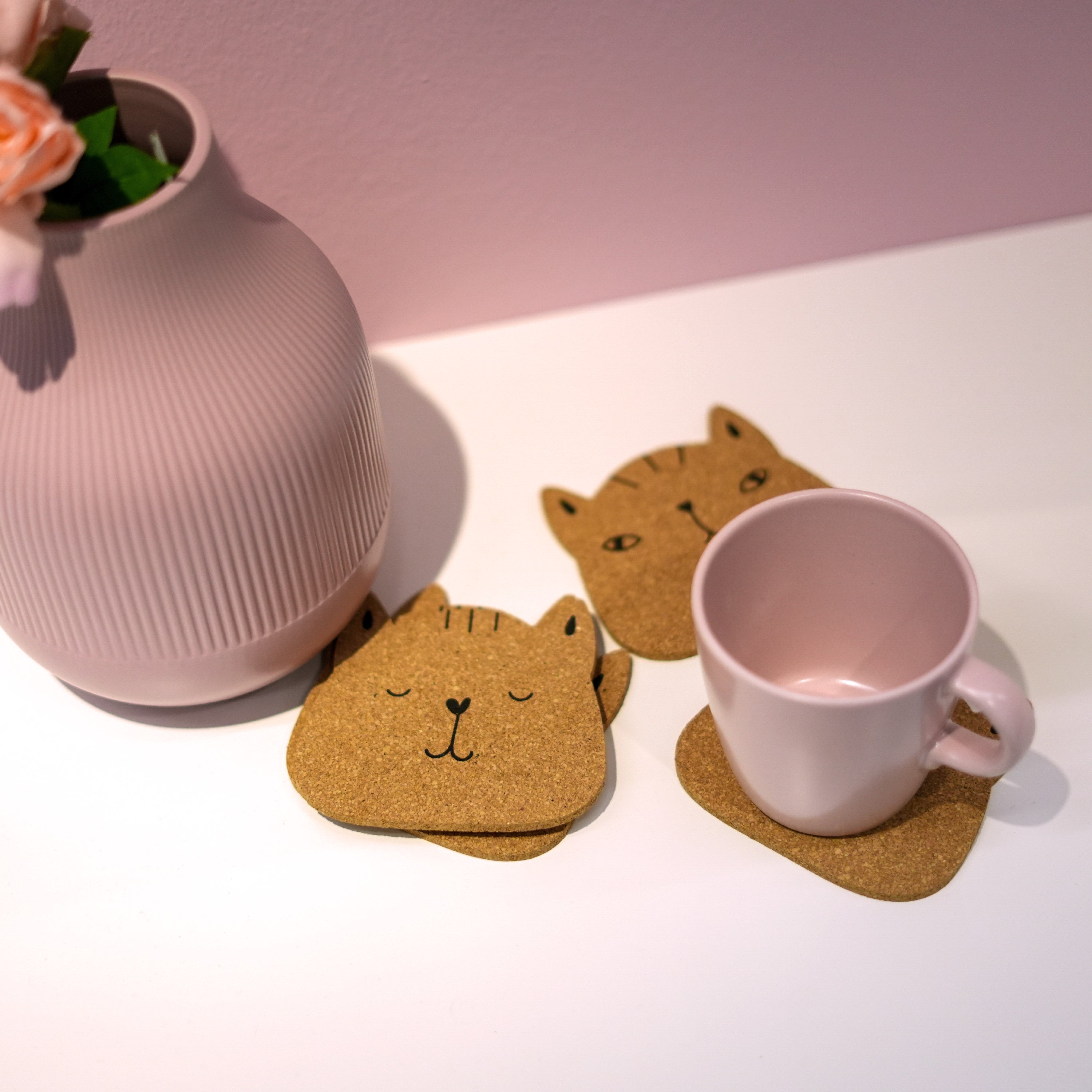 Set of 6 round cork coasters featuring different cute cat faces, perfect for protecting furniture and showcasing love for cats.