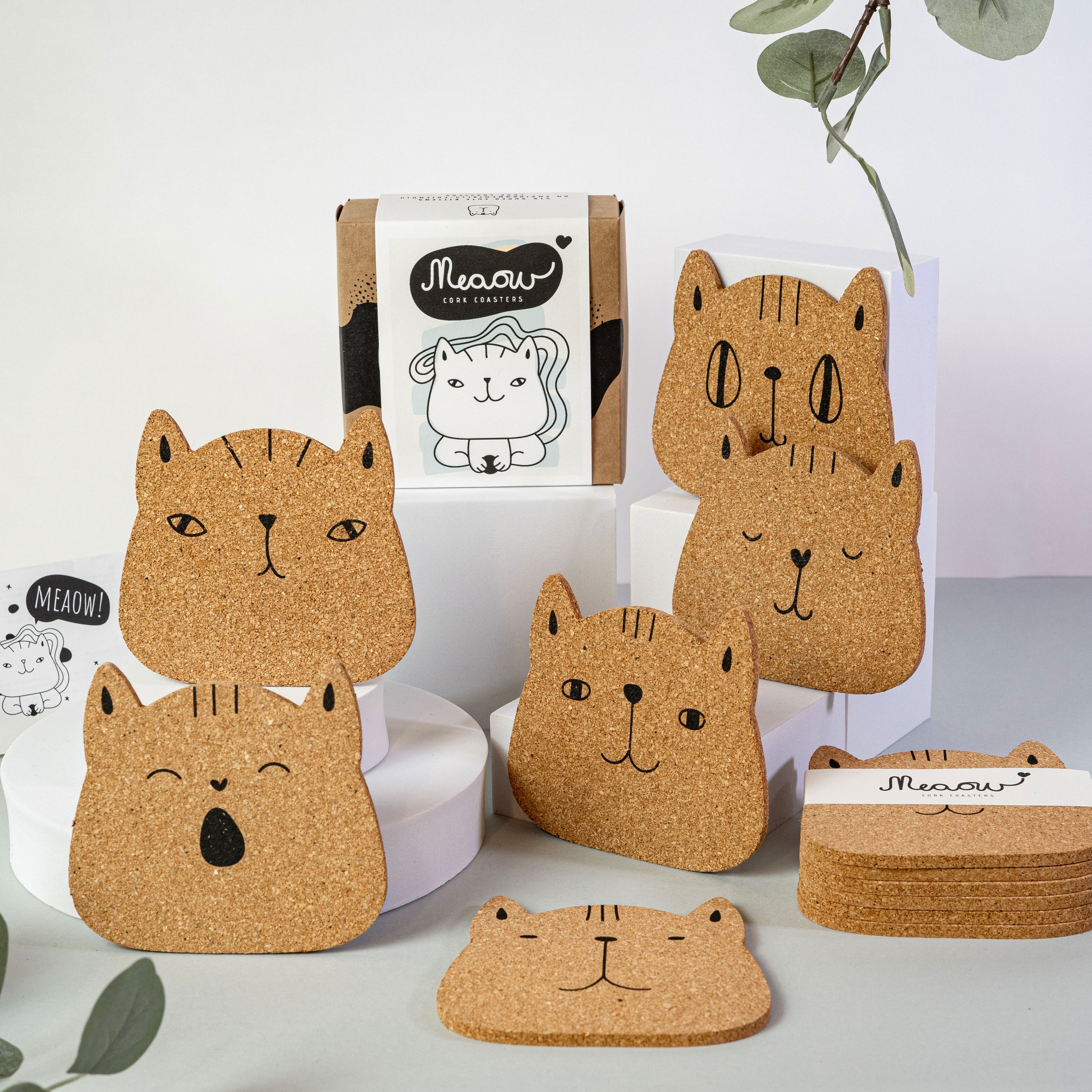 Set of 6 round cork coasters featuring different cute cat faces, perfect for protecting furniture and showcasing love for cats.