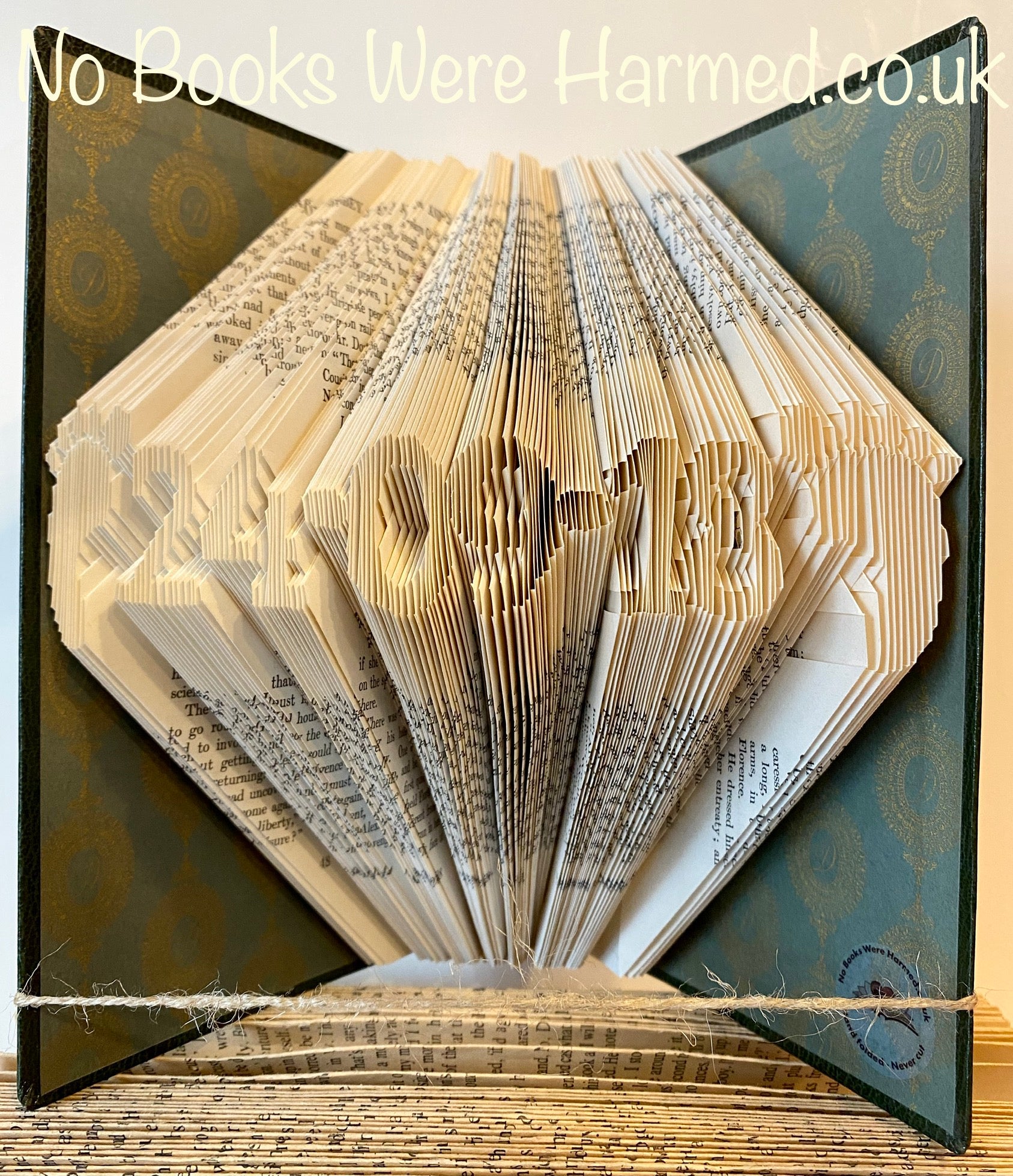 Handcrafted Mini Date art featuring baby foot design, made from vintage book pages, showcasing intricate folds and unique character.
