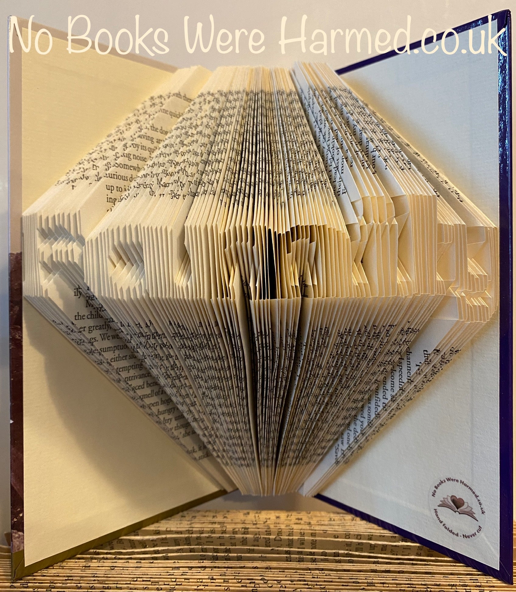 Mini 'Family' art piece handcrafted from vintage books, showcasing unique hand-folded pages in a charming design.