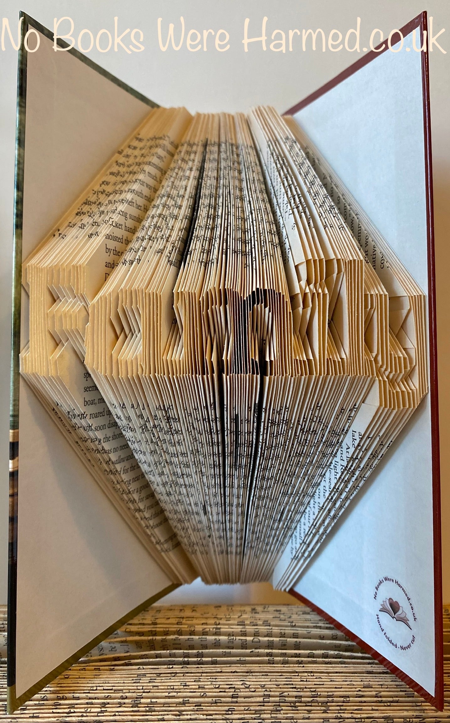 Mini 'Family' art piece handcrafted from vintage books, showcasing unique hand-folded pages in a charming design.