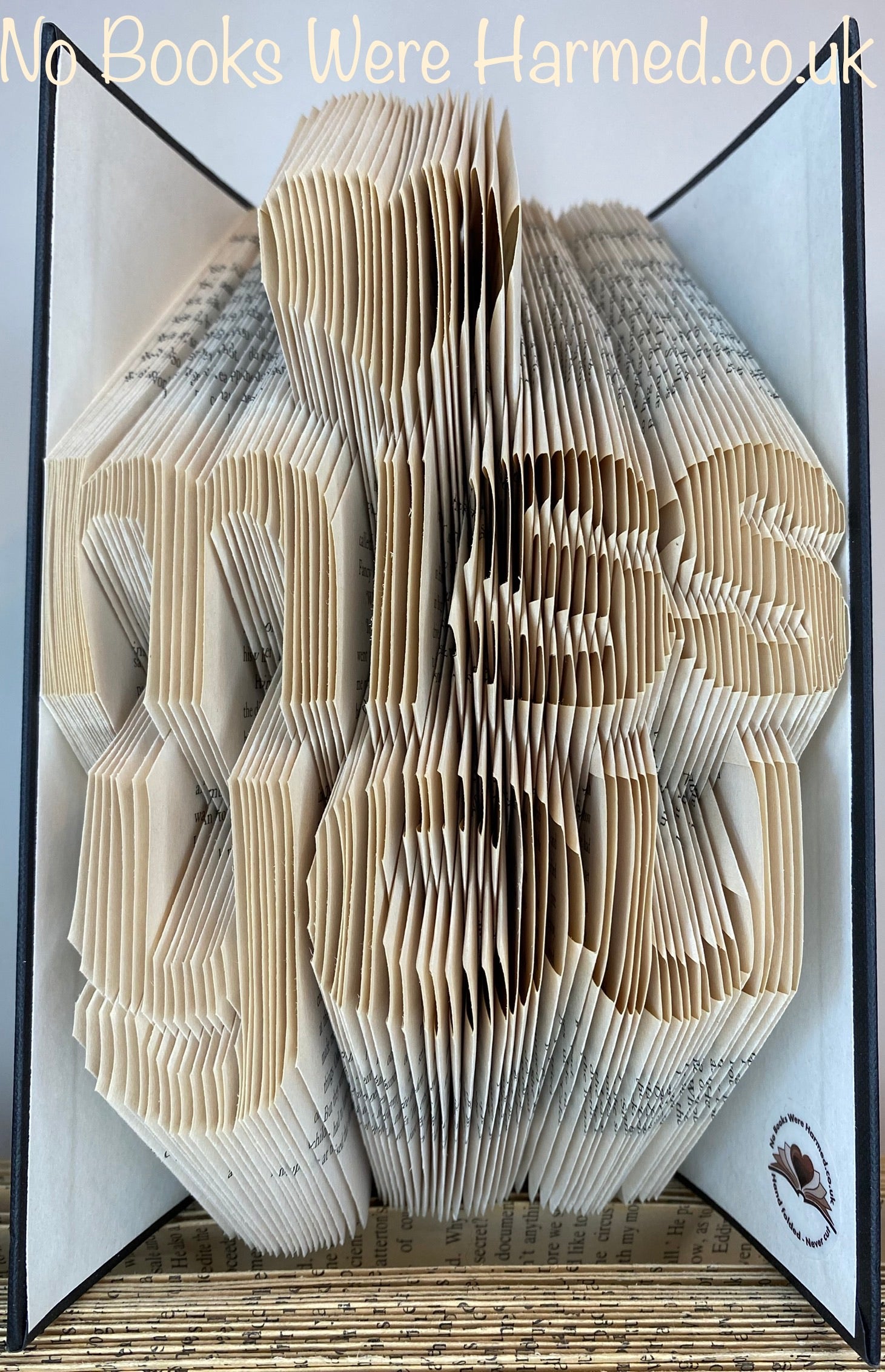 A unique hand-folded book art piece titled 'Miss You', crafted from vintage books, showcasing intricate designs and textures.