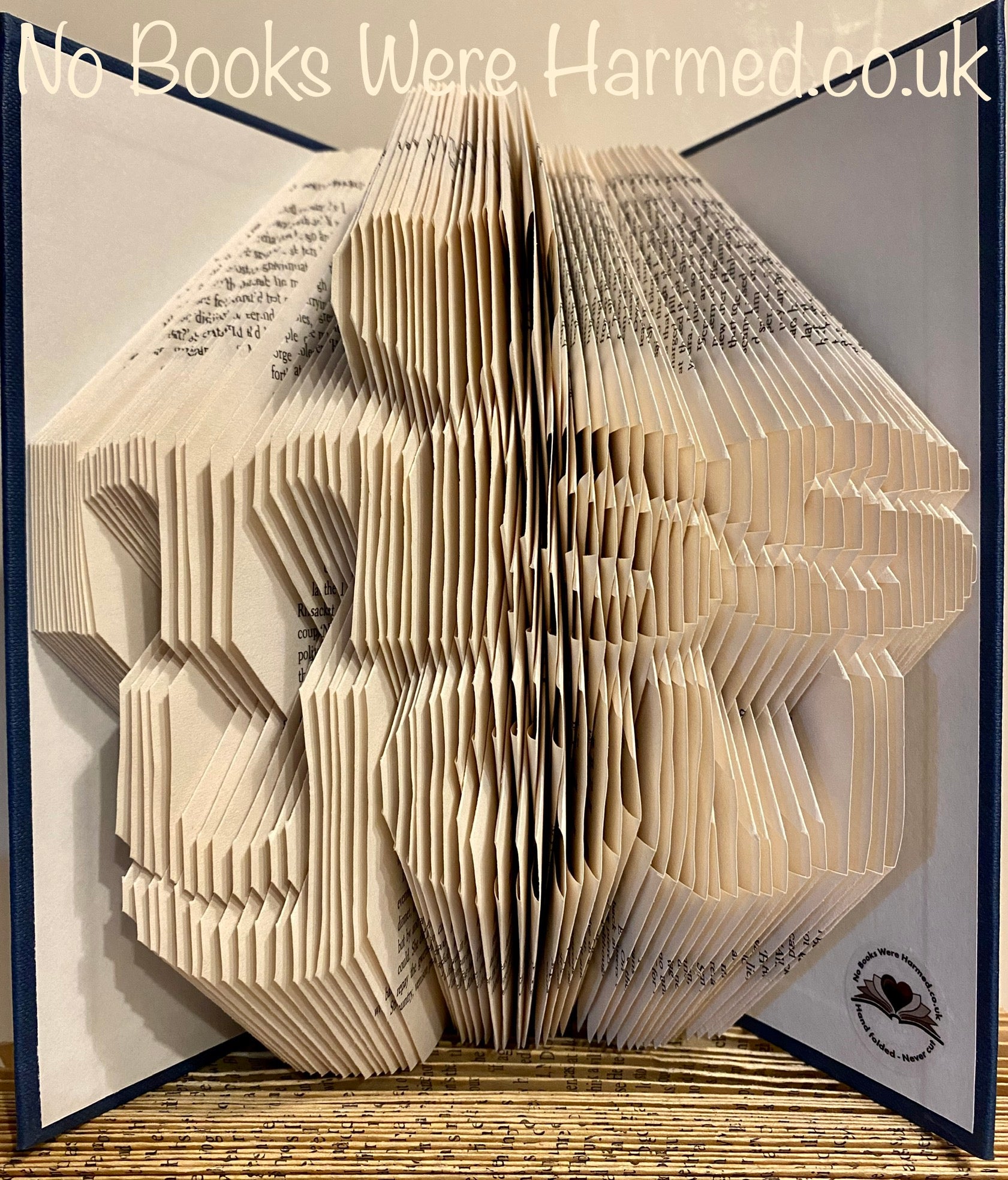 A unique hand-folded book art piece titled 'Miss You', crafted from vintage books, showcasing intricate designs and textures.