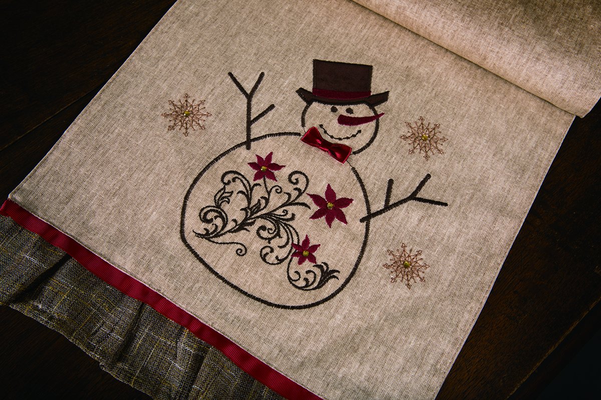 ML14899 Snowman Table Runner featuring embroidered snowman design with jewel accents and ruffle trim, perfect for holiday decor.