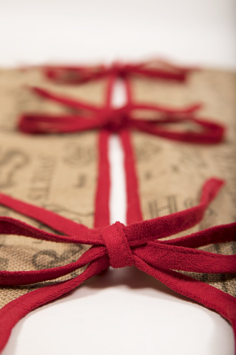 ML14900 Saint Nick Burlap Tree Skirt featuring a whimsical Santa design with red piping, perfect for holiday decor.