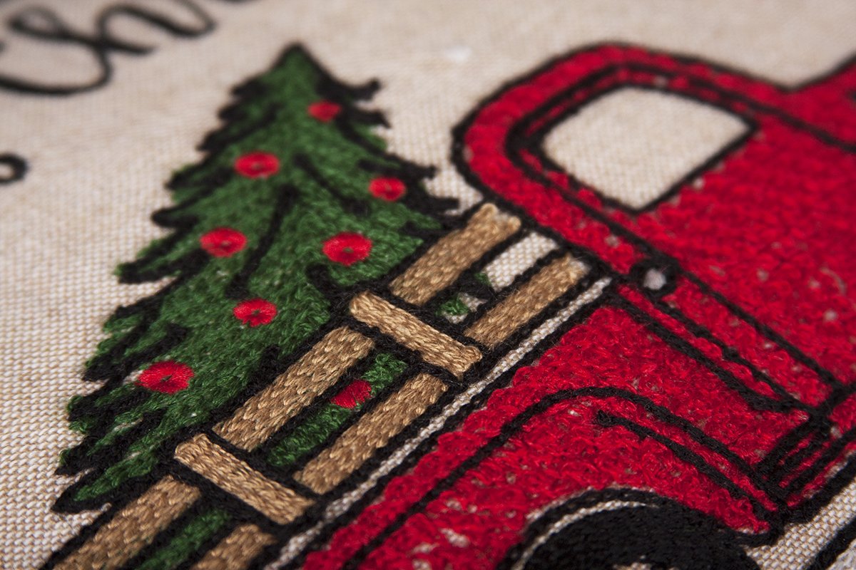 A decorative Christmas pillow featuring a whimsical red pick-up truck design, perfect for holiday decor.