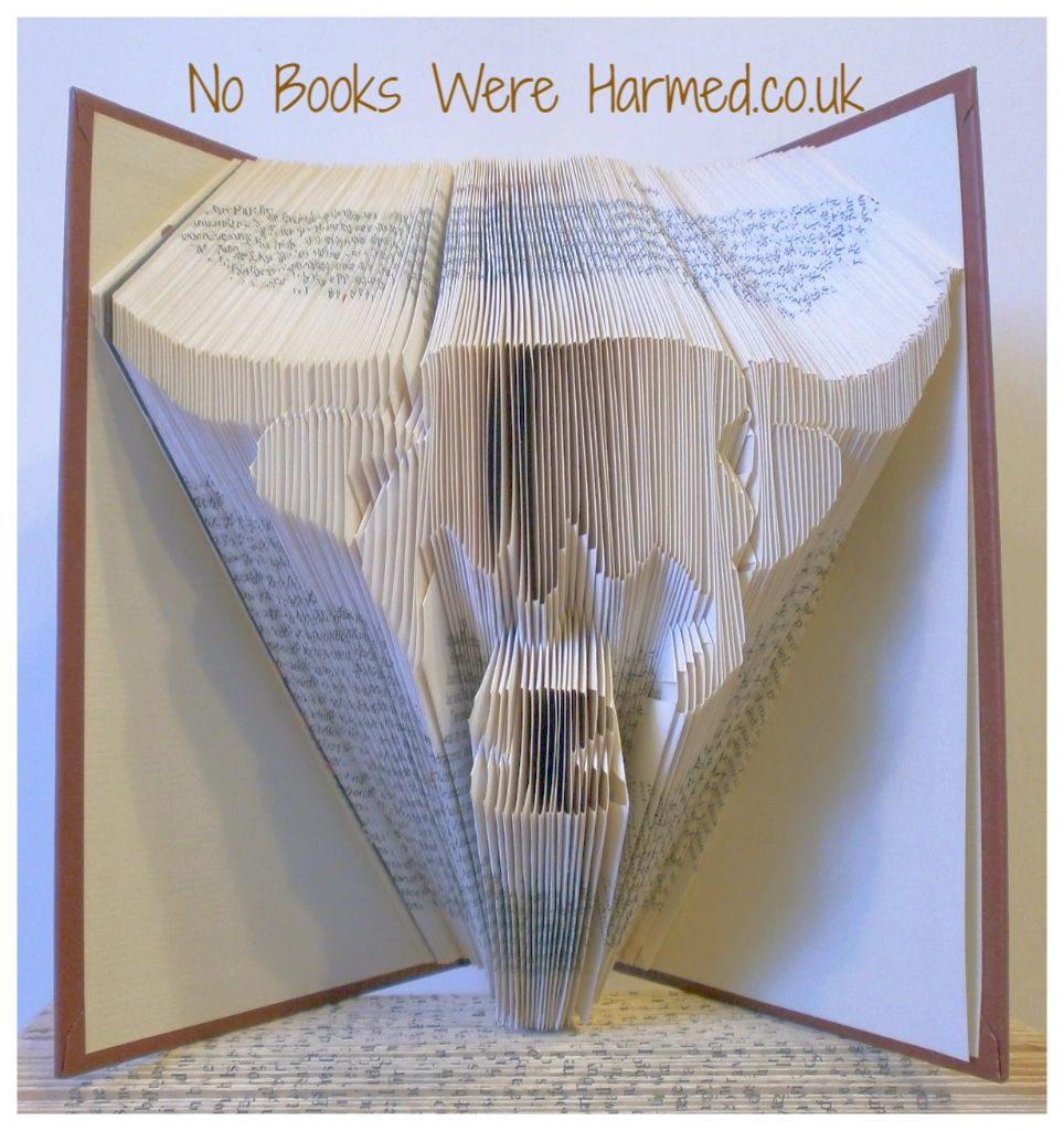 Handcrafted Scottish Highland Cow made from vintage books, showcasing unique colors and intricate hand-folding.